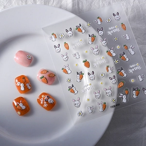 Close-up of cute rabbit and carrot nail stickers applied on nails with Hello Spring text.