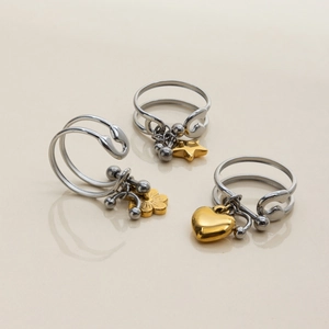 Detailed view of two-tone open rings with gold star, flower and heart pendants