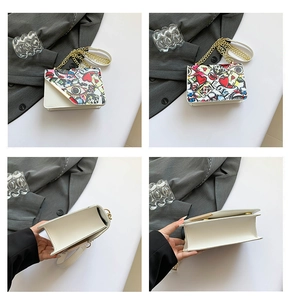 Detail view of white graffiti crossbody bag with golden chain and colorful love patterns