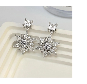Macro view of 14k gold plated snowflake drop earrings with sparkling zircon crystals