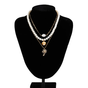 Detail of multi-layer beaded necklace with starfish shells and coconut tree pendants