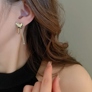 Detailed view of silver liquid heart earrings on model with high gloss metallic finish