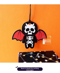 Close-up of Halloween skull tag with red bat wings on festive orange background