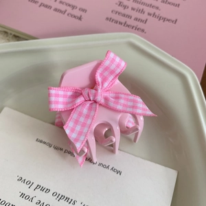 Close-up of a pink hair claw clip featuring a pink and white checkered ribbon bow