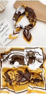 Detailed equestrian print on square silk scarf with stirrup and belt patterns on white tray