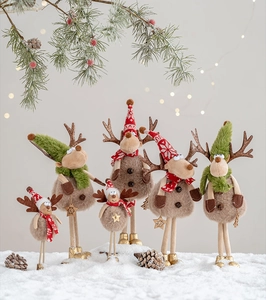 Gruppo di renne di Natale in peluche con sciarpe e cappelli in maglia sulla neve