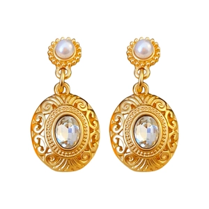 Vintage gold pearl earrings with hollow oval crystal pendant on a white background