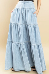 Dettaglio della gonna lunga in denim azzurro con balze a strati e cuciture