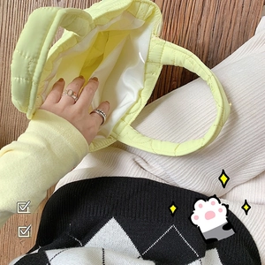 Internal view of quilted yellow tote bag showing soft white lining and organizer pocket