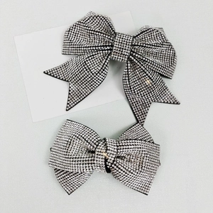 Macro detail of high-end rhinestone bow hair clips in silver and black colors