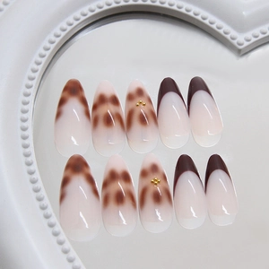 Brown tortoiseshell and cream almond press-on nails with golden pearl bead accents