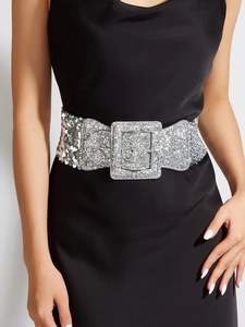 Détail d'une large ceinture à paillettes argentées avec une grande boucle métallique