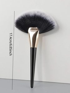 Macro shot of large fan-shaped makeup brush with soft bristles and gold ferrule detail