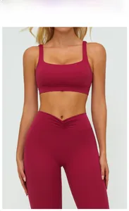 Detail view of cherry red yoga set featuring V-shaped cross high waist leggings and sports bra