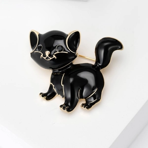 Detail of a vintage black enamel puppy brooch with gold trim and black rhinestone eyes