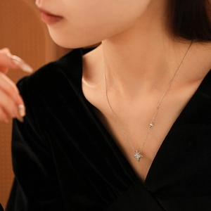 Gros plan d'un collier pendentif étoile à quatre branches en argent avec pierre centrale