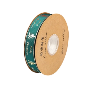 Green Christmas ribbon with gold Merry Christmas lettering and trees on paper spool