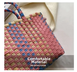 Close-up of colorful woven bucket bag showing pink, blue and yellow handmade patterns
