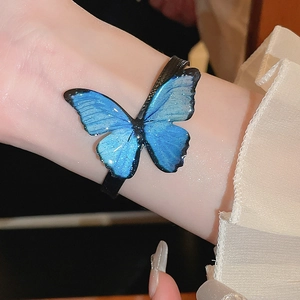 Macro shot of a blue butterfly bracelet with glitter finish on a wrist