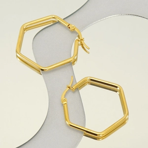 Minimalist gold geometric hexagon hoop earrings displayed on a reflective mirror surface