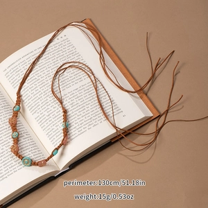 Detail of bohemian braided waist rope with turquoise beads on a vintage book