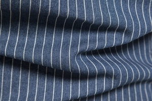 Macro shot of striped denim fabric showing detailed blue and white woven texture