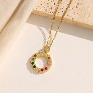 Gold titanium necklace with a colorful zircon donut pendant on a luxury silk background