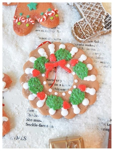 Macro shot of resin gingerbread man and holiday wreaths on festive snowy background