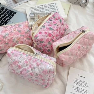 Quilted floral makeup bags in four patterns on a soft white background with accessories