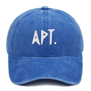 Macro detail of white APT. letter embroidery on blue washed cotton baseball cap