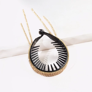 Black round hair comb with golden rhinestones and tassel chains on white background