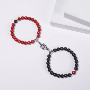 Detail of magnetic handshake clasp connecting red and black natural stone beaded bracelets