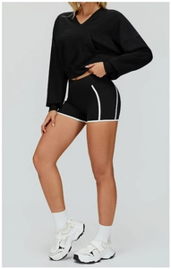 Side view of black hooded sports jacket with white trim and matching compression shorts