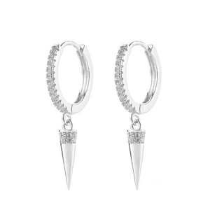 Detalle de pendientes huggie de plata con colgantes en punta y piedras de circonita cúbica