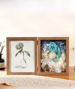 Close-up of walnut wood folding frame with blue preserved roses and dried flowers detail