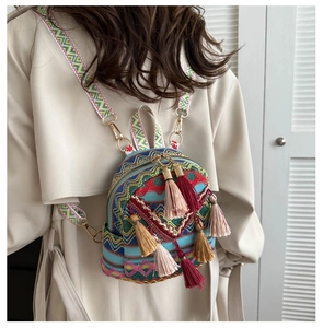 Close-up of bohemian woven mini backpack with colorful geometric patterns and tassels