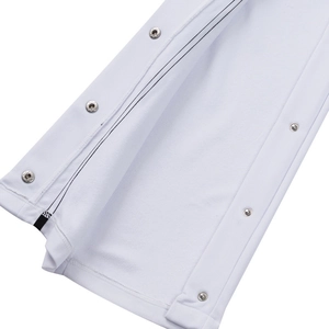 Detail of white sports joggers featuring metallic side snaps and premium knit fabric