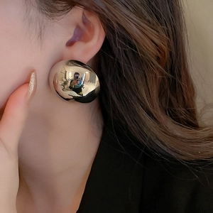 Macro detail of chunky silver irregular pebble earrings with a polished mirror finish