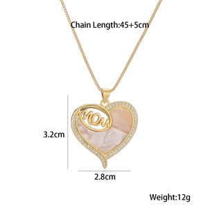 Macro shot of gold-plated MOM heart pendant with pink marble shell inlay and small crystals