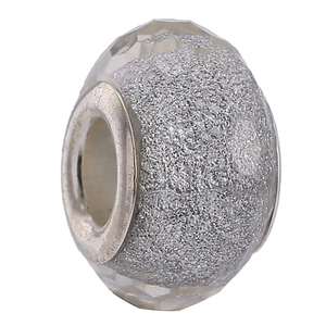 Close-up of a silver resin bead with sparkling gray glitter and a large central hole