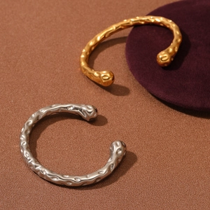 Minimalist open bangle with irregular lava texture in gold and silver finish