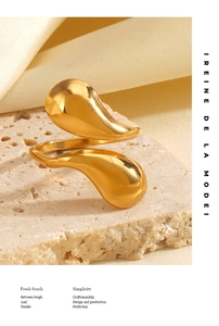 Detailed view of an 18K gold-plated teardrop ring on a textured stone surface