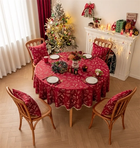 Detail of red Christmas tablecloth with golden reindeer patterns and lace edging
