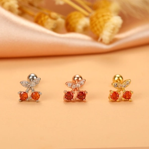 Detail view of cherry earrings with red stones and sparkling leaves in three metal finishes