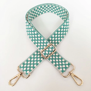Detail of adjustable woven bag strap in teal and white with gold metal hardware
