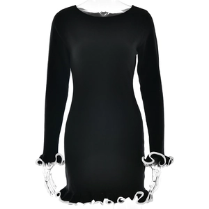 Detail of the black rib-knit dress featuring white ruffled hem and sleeve cuffs