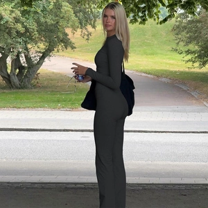 Detail of black slim fit long sleeve top and flared pants set in an outdoor setting