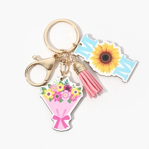Detail of wooden MOM keychain with pink tassel, flower bouquet, and sunflower pendant
