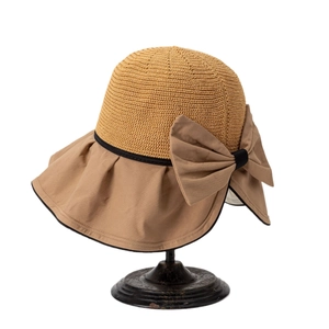 Women's summer straw sun hat with wide brim, ruffled edge and khaki bow on display stand