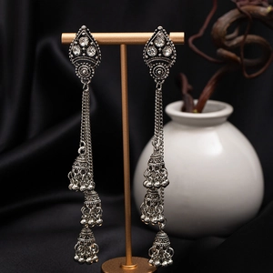 Macro detail of vintage silver triple-layered Jhumka earrings with tassels and rhinestones